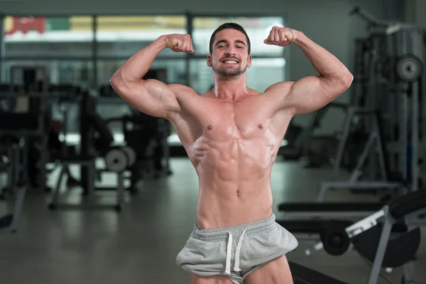 Detalj av en Bodybuilder poserar i gymmet — Stockfoto