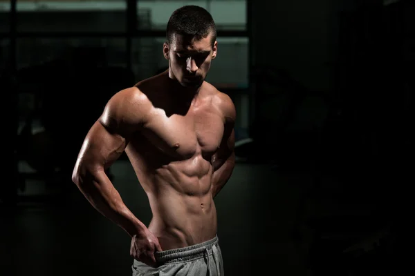 Man In de sportschool zijn goed opgeleide lichaam tonen — Stockfoto