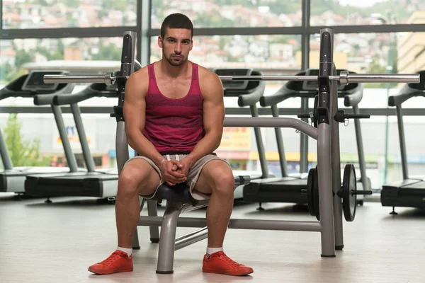 Attraente giovane uomo che riposa rilassato in palestra — Foto Stock