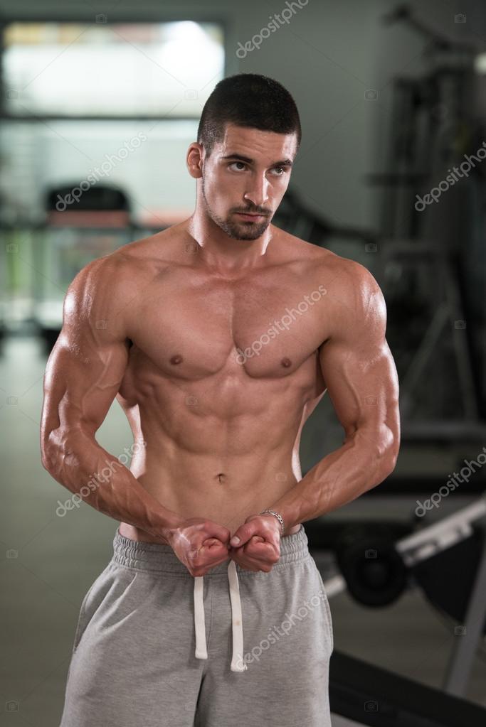 Muscular Man Flexing Abdominal Muscles Abs In A Health Club Stock