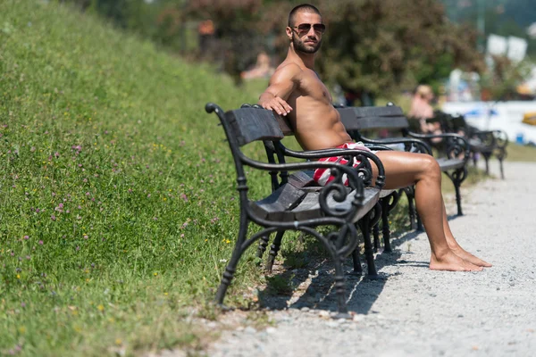 Knappe jongen rustend op Bench Outdoors — Stockfoto