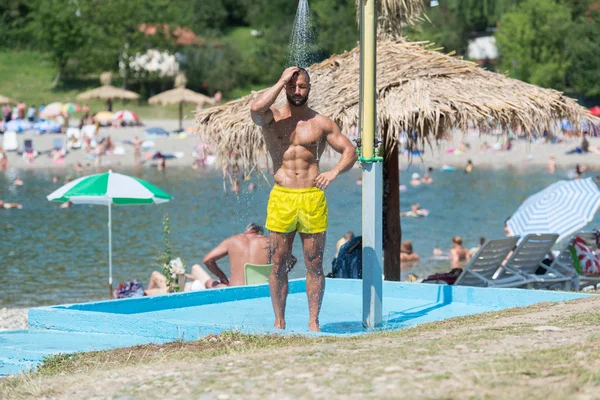 Schöner Muskelmann nimmt eine Dusche im Freien — Stockfoto