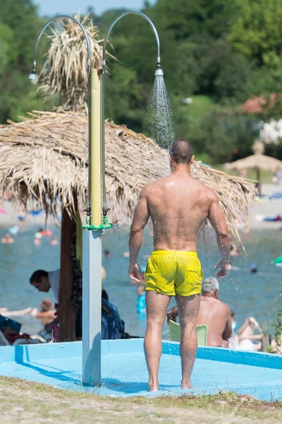Przystojny mięśni mężczyzna bierze prysznic na zewnątrz — Zdjęcie stockowe