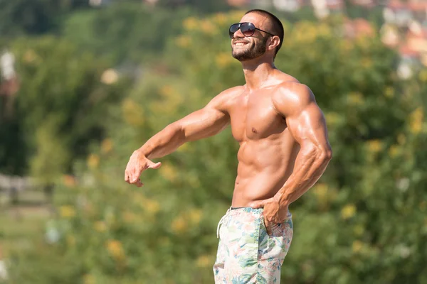 Мужчина разминает мышцы на открытом воздухе в летнее время — стоковое фото