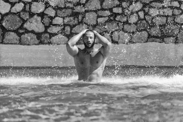 Uomo muscolare in piedi sotto un'acqua — Foto Stock