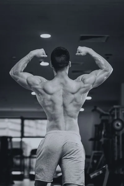 Detalle de un culturista posando en el gimnasio — Foto de Stock