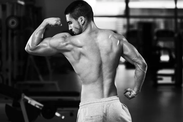 Detalle de un culturista posando en el gimnasio — Foto de Stock