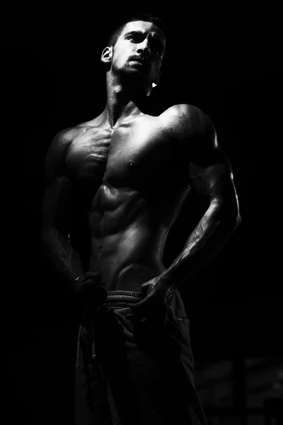 Testépítő férfi pózol az edzőteremben — Stock Fotó