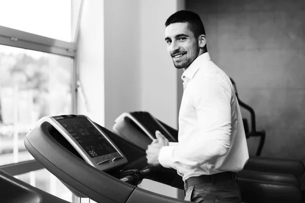 Uomo d'affari che corre sul tapis roulant in palestra — Foto Stock