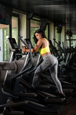 Latin kadın Fitness salonunda eliptik koşu bandı