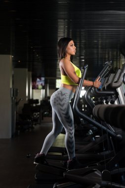 Latina kadınların Fitness salonunda eliptik koşu bandı