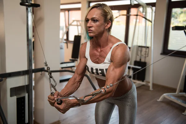 Gespierde Bodybuilder vrouw uitvoeren kabel Crossover — Stockfoto