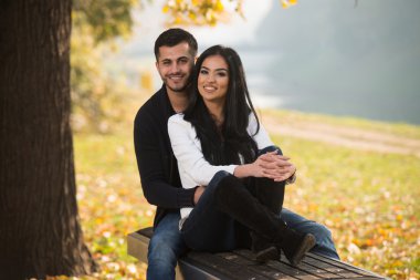 Çift rahatlatıcı sonbahar parkta bankta