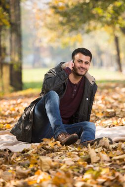 Sonbahar sonbaharda cep telefonda konuşan adam