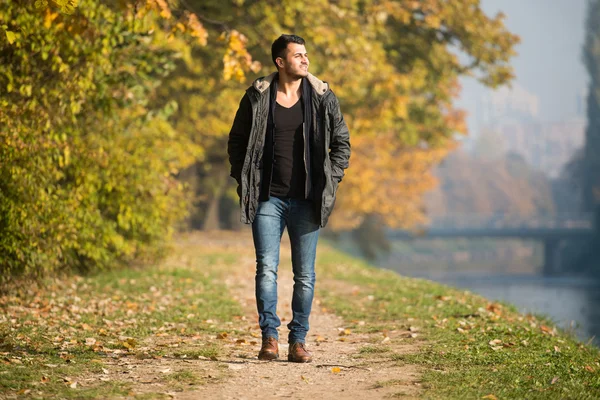 Sonbahar ormanda yürüyen genç adam — Stok fotoğraf