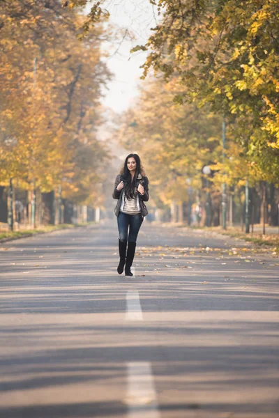 Sonbahar ormanda yürüyen genç bir kadın — Stok fotoğraf