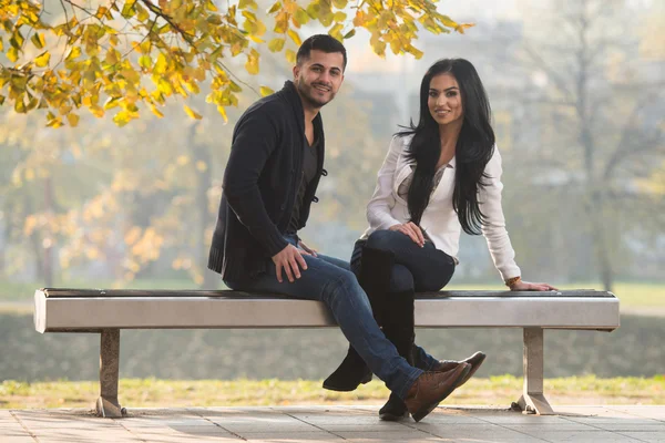 Couple se détendre sur le banc dans le parc d'automne — Photo