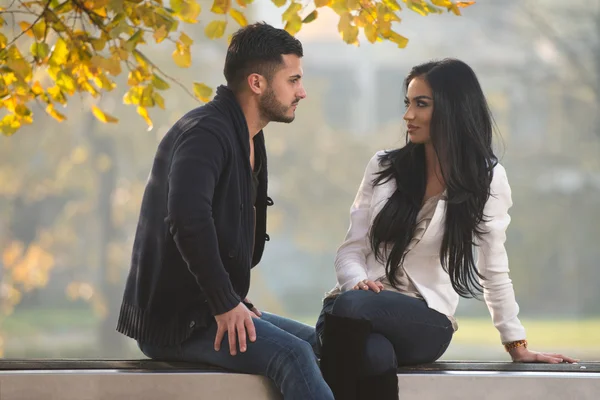 Casal romântico em um banco no parque de outono — Fotografia de Stock