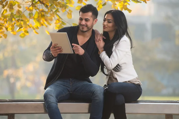 Pareja feliz con Tablet Computer en el parque —  Fotos de Stock