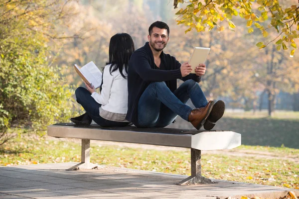 Couple Look At A Digtial Tablet And Book — Stock Photo, Image
