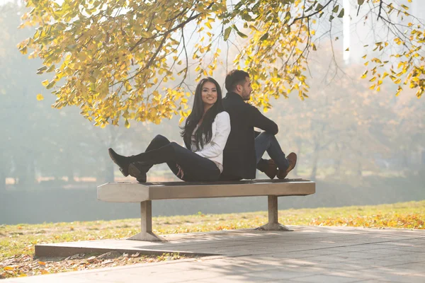 Çift rahatlatıcı sonbahar parkta bankta — Stok fotoğraf