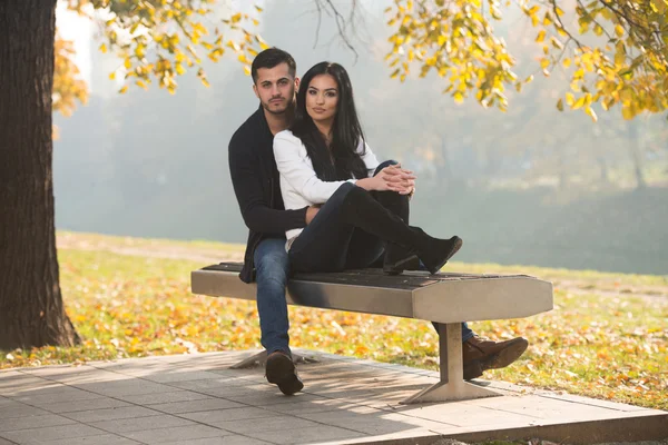 Romantický pár na lavičce v parku na podzim — Stock fotografie