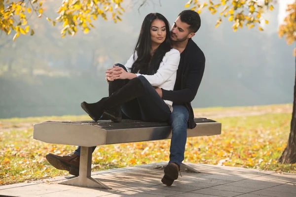 Coppia romantica su una panchina nel parco d'autunno — Foto Stock