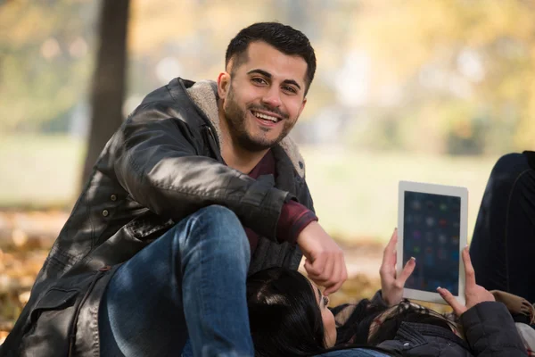 Pareja feliz con Tablet Computer en el parque —  Fotos de Stock