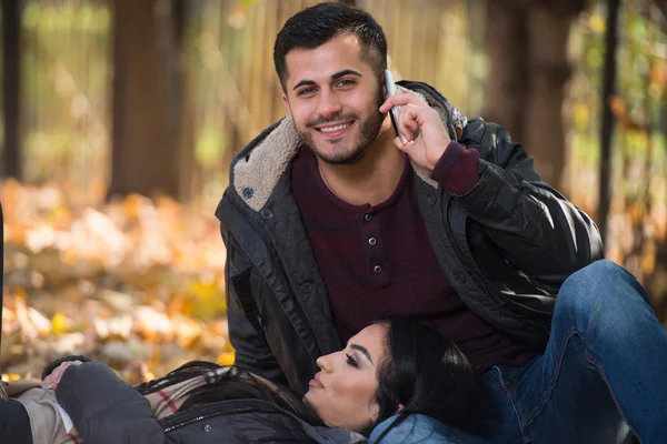 Pojkvännen pratar i telefon medan han njuter av höstparken — Stockfoto