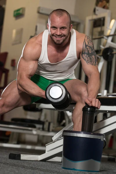 Hombre haciendo ejercicio para las píldoras de bíceps y la droga —  Fotos de Stock