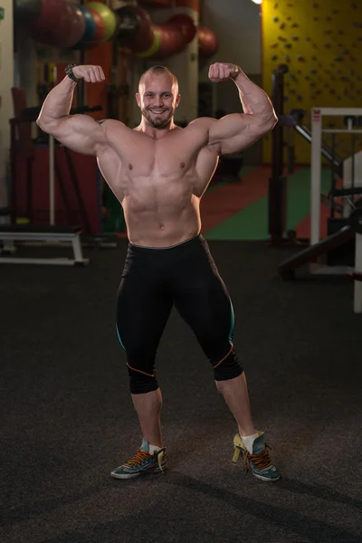 Bodybuilder presterende achterste dubbele biceps vormen — Stockfoto