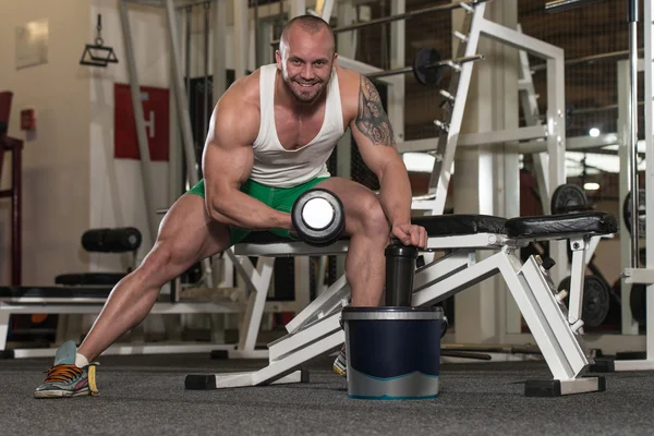 Hombre haciendo ejercicio para las píldoras de bíceps y la droga —  Fotos de Stock