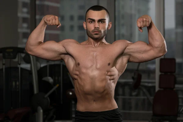 Hombre en el gimnasio mostrando su cuerpo bien entrenado — Foto de Stock