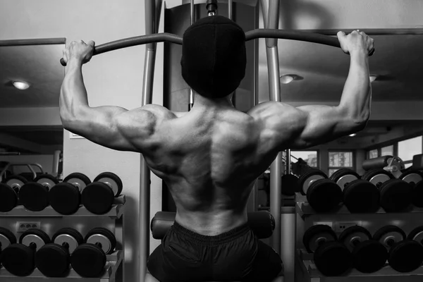 Joven macho haciendo ejercicios de espalda en el gimnasio —  Fotos de Stock