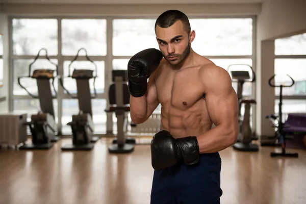 Jeune homme athlétique avec gants de boxe — Photo
