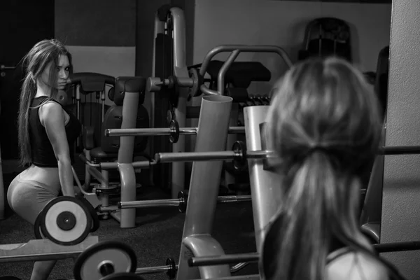 Jovem mulher fazendo exercício halteres agachamento — Fotografia de Stock