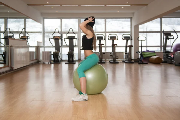 Junge glückliche Frau trainiert mit Fitnessball — Stockfoto