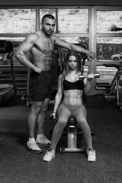 Jovem casal fazendo peso pesado exercício para bíceps — Fotografia de Stock