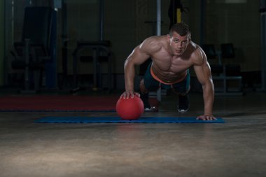 Basın yapan genç erkek sağlık topu üzerinde Ups 