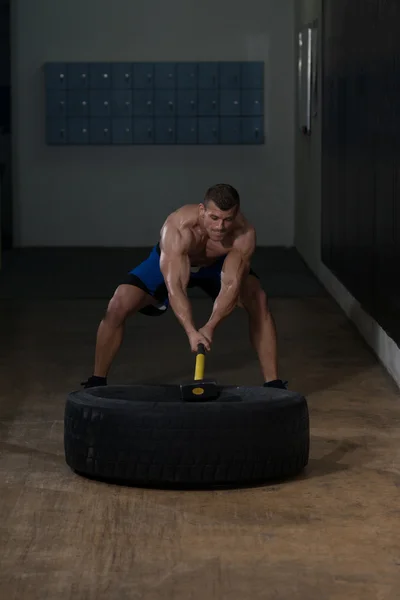 Entrenamiento en el gimnasio con martillo y neumático de tractor —  Fotos de Stock