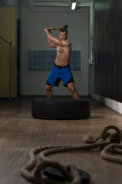 Entraînement au gymnase avec marteau et pneu tracteur — Photo