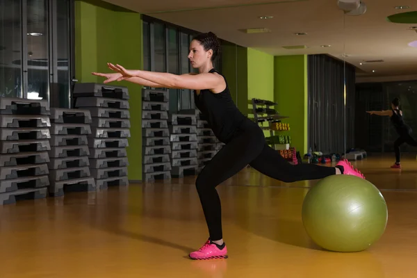 Kvinna som arbetar ut med bollen i gymmet — Stockfoto