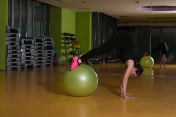 Kvinna som arbetar ut med bollen i gymmet — Stockfoto