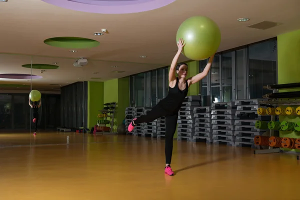 Kvinna som arbetar ut med bollen i gymmet — Stockfoto