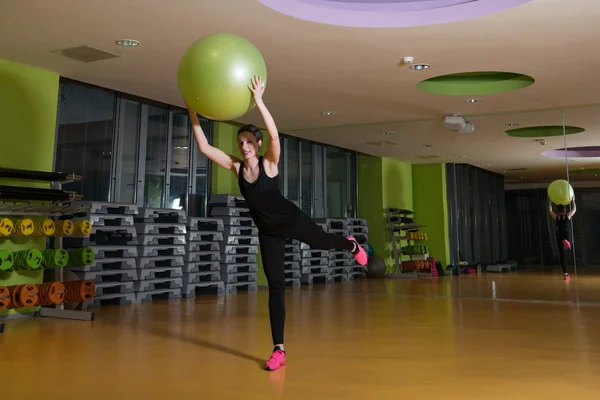 Mujer haciendo ejercicio con pelota en el gimnasio —  Fotos de Stock