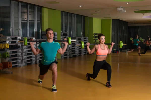 Giovane coppia che fa esercizio fisico pesante per le gambe — Foto Stock