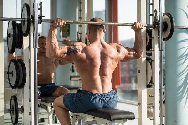 Fisiculturista masculino fazendo exercício de peso pesado para ombros — Fotografia de Stock