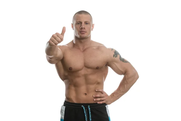 Bodybuilder zeigt Daumen nach oben über weißem Hintergrund — Stockfoto