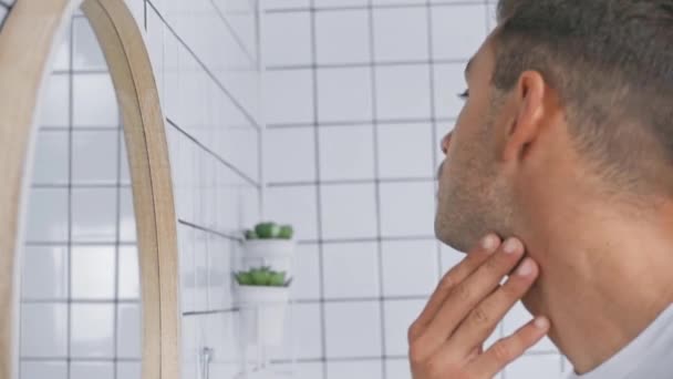 Jovem Homem Tocando Rosto Enquanto Olha Para Espelho — Vídeo de Stock