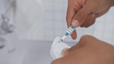 Diş fırçasında diş macunu sıkan adamı çekmeye odaklan. 